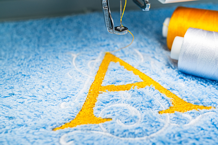 Nähmaschine Memmingen - gestickter Buchstabe A in gelber Farbe auf einem hellblauen Stoff