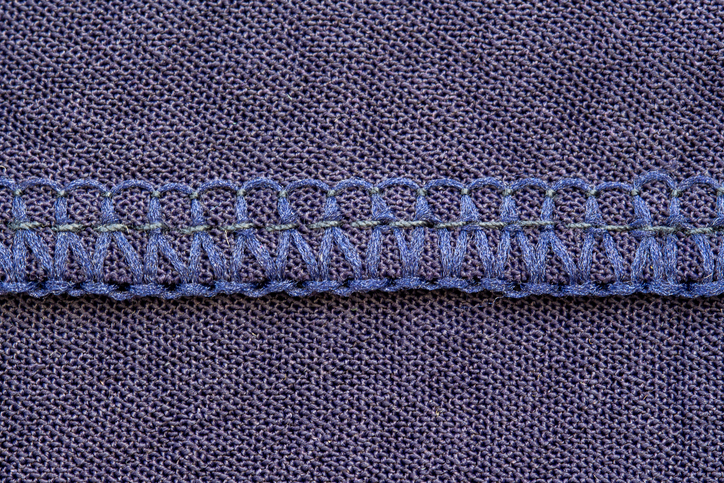 Nähmaschine Memmingen - Blaue Overlocknaht auf einem dunkelblauen Stoff